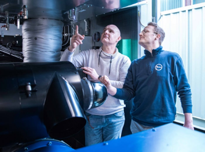 Rolf Janssen Diesel Netzersatzanlagen im Container mit zwei Mitarbeiter